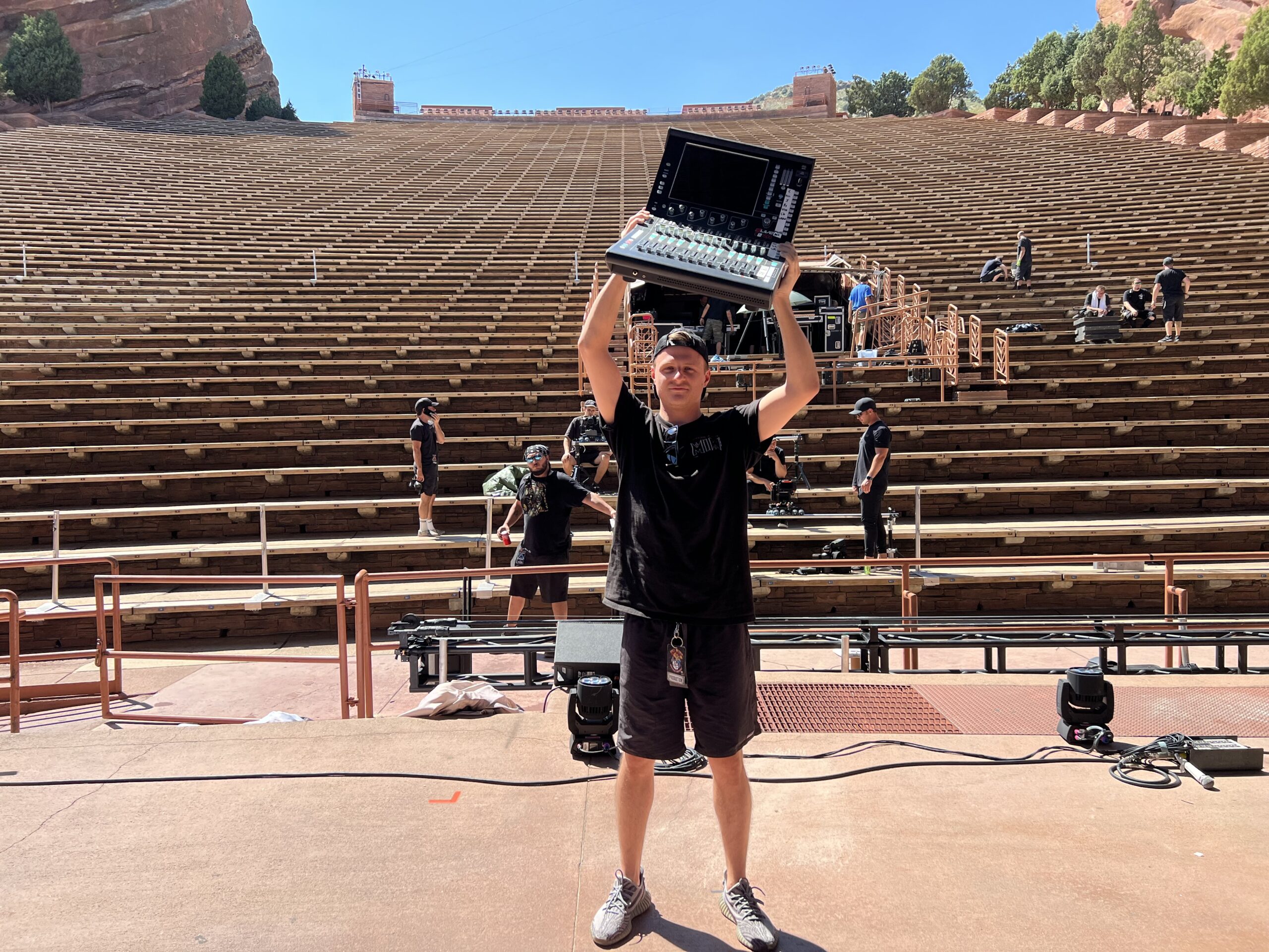 FOH engineer and tour manager Logan Beaver holding a dLive CTi1500 above his head